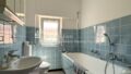 Badezimmer mit blauen Fliesen und Badewanne