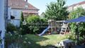 Garten mit grünem Rasen und Rutsche